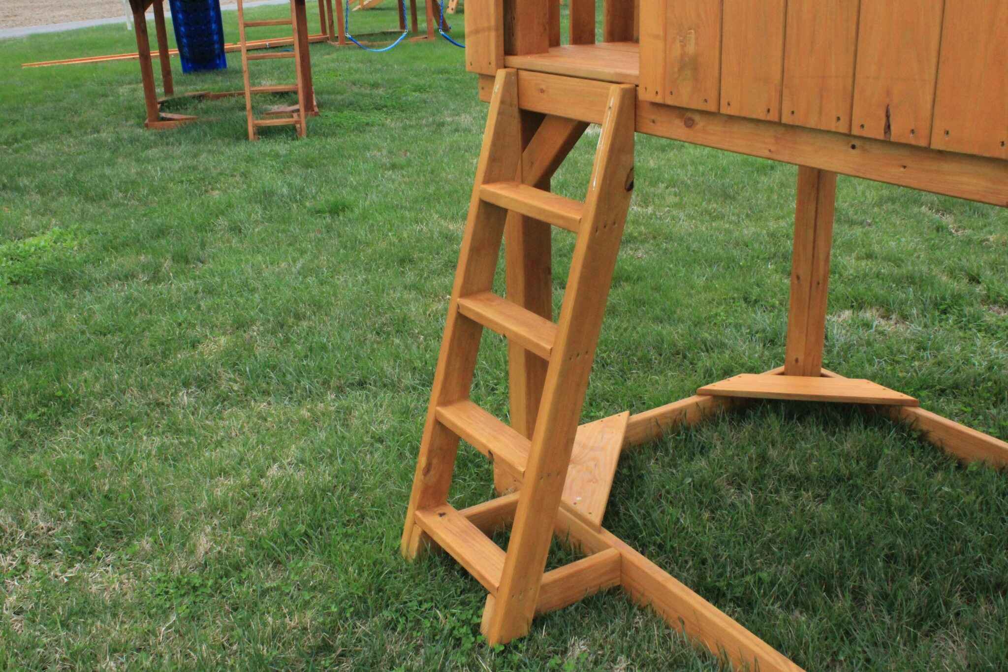 Our heavy-duty ladder features flat steps rather than round rungs for easier climbing. Angled for stability and equipped with handles at the top, it is built from pressure-treated lumber for lasting durability.